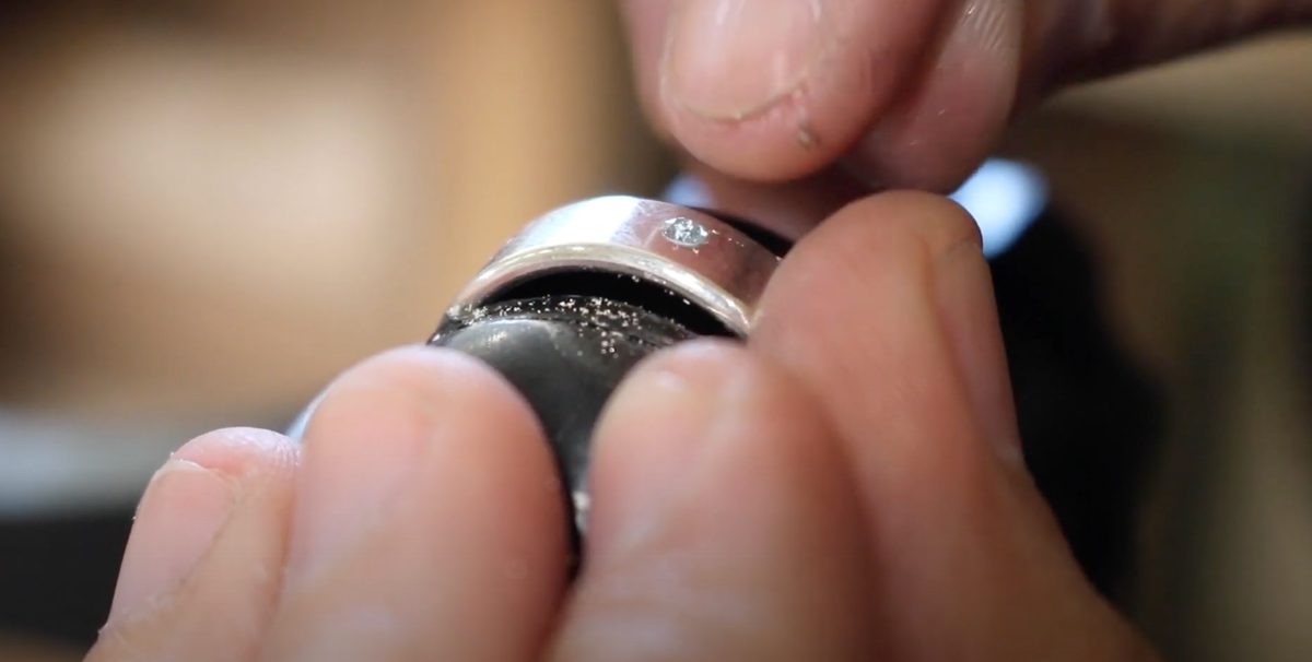 Placing the gemstone into the seat, level with the surface